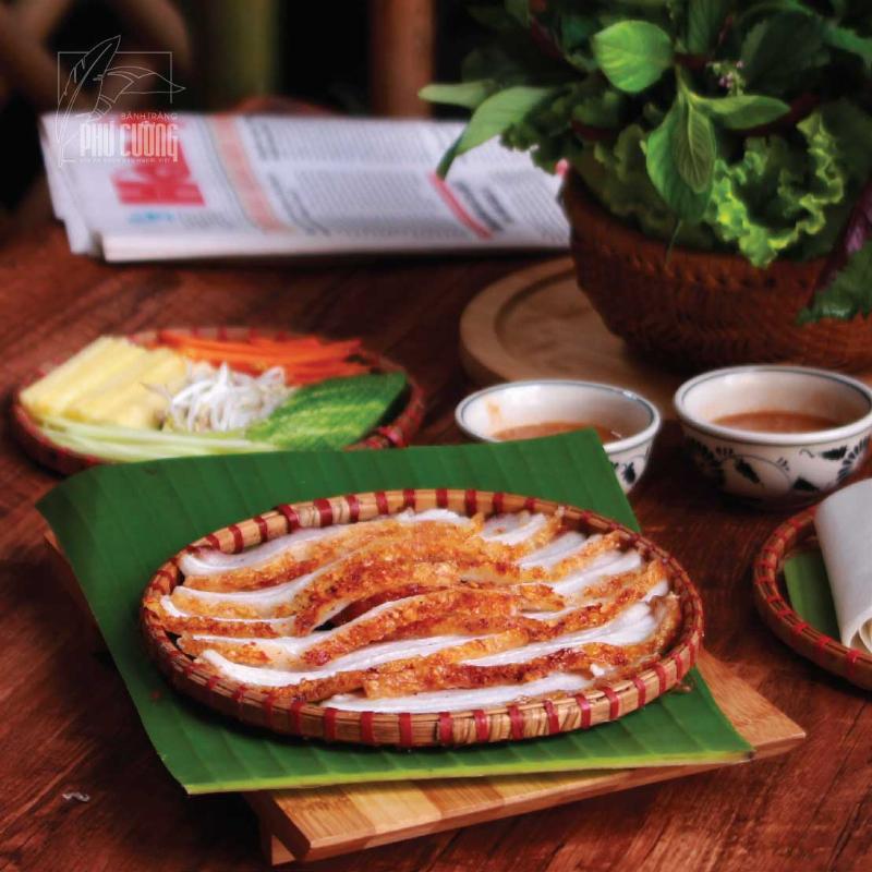 Thịt heo quay giòn bì, vàng ươm, thơm phức đặt trên đĩa, trang trí với rau thơm và dưa leo.